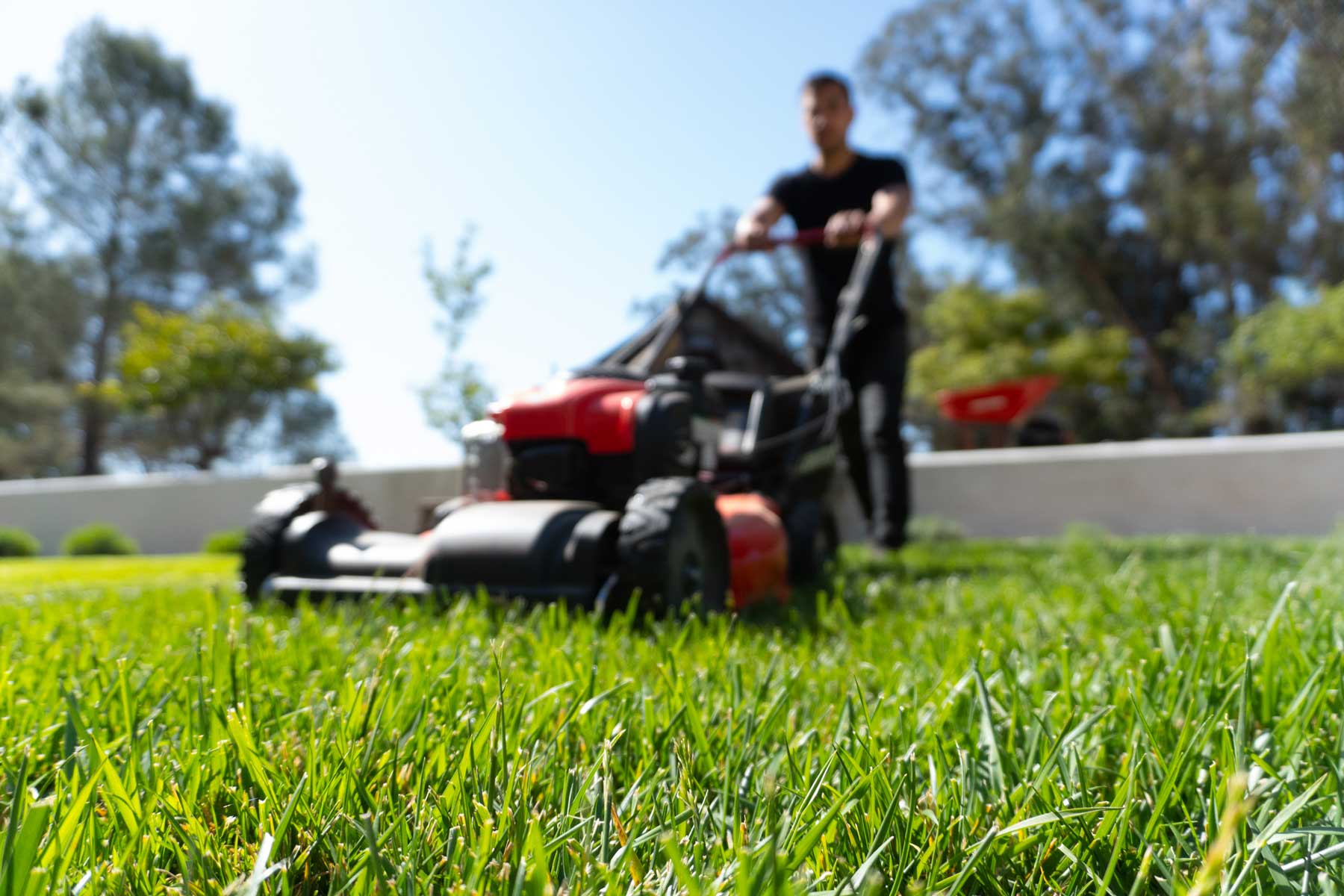 Unique Garden Services | About Us | Person mowing lawn