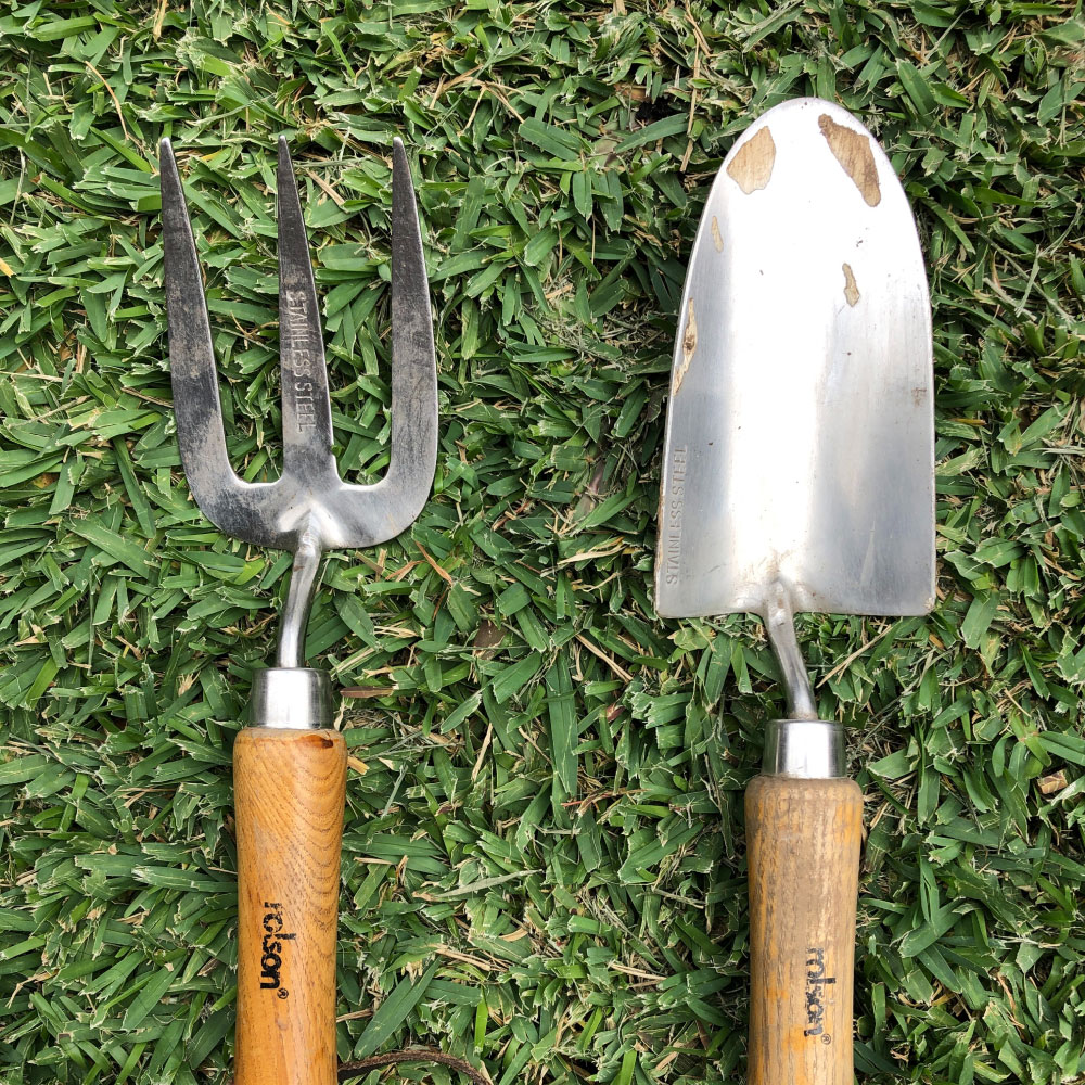 Unique Garden Services | Homepage | About Us | gardening tools laid on lawn